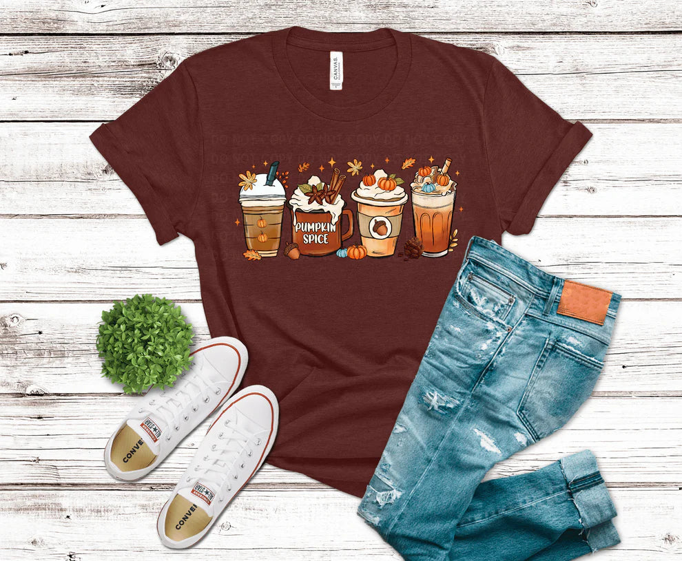 Maroon t-shirt with pumpkin spice latte design, blue jeans, and white sneakers on a wooden surface.
