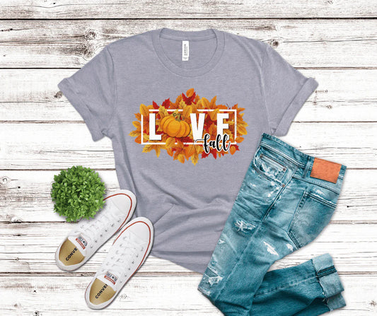 Gray t-shirt with 'LOVE fall' design, white sneakers, and blue jeans on a wooden surface