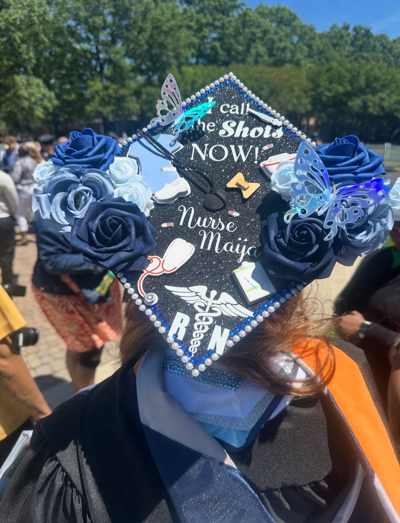 A decorated graduation cap with blue flowers and texts for medical field, nurse, doctor